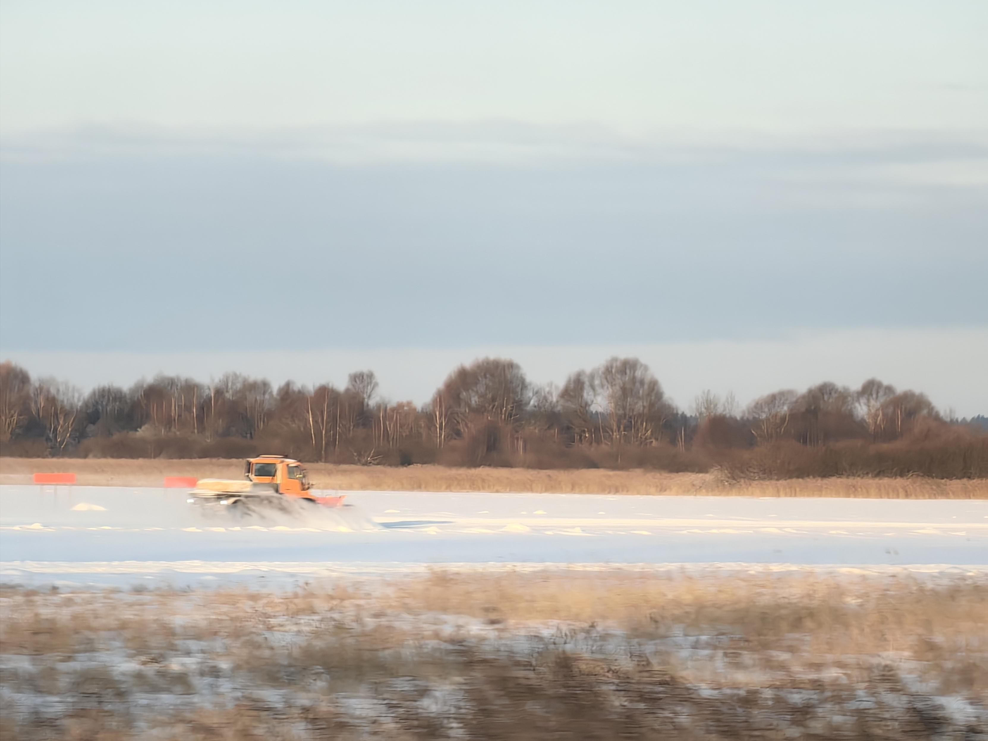 Snow plow cleaning runway of Spilve Airport.