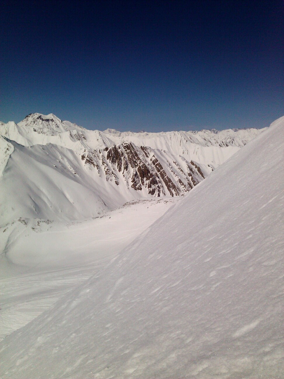 Snow, mountains. Steep freeride are left of the Sadzele peak.