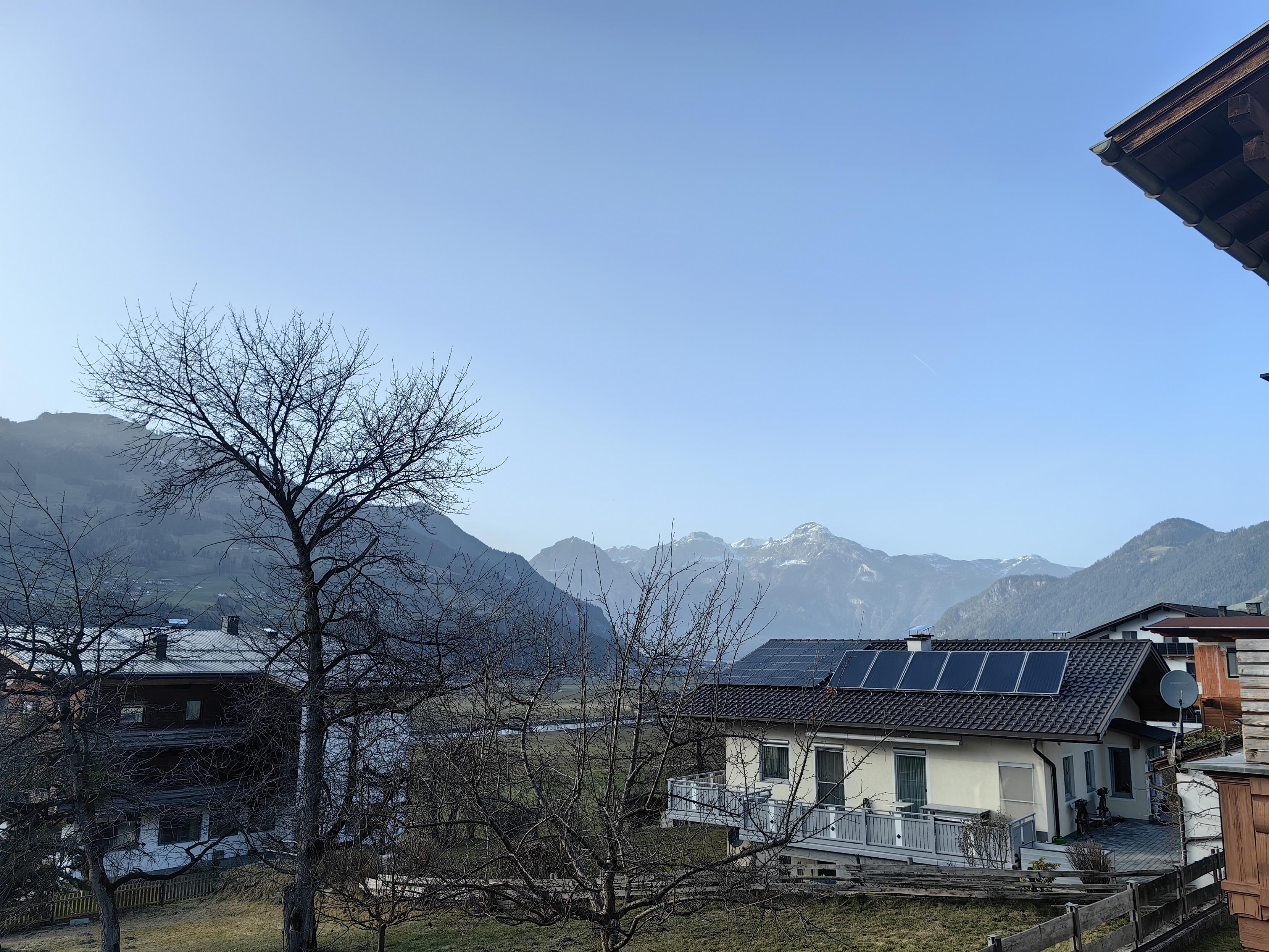 Mountain village houses in foreground, mountains in background.
