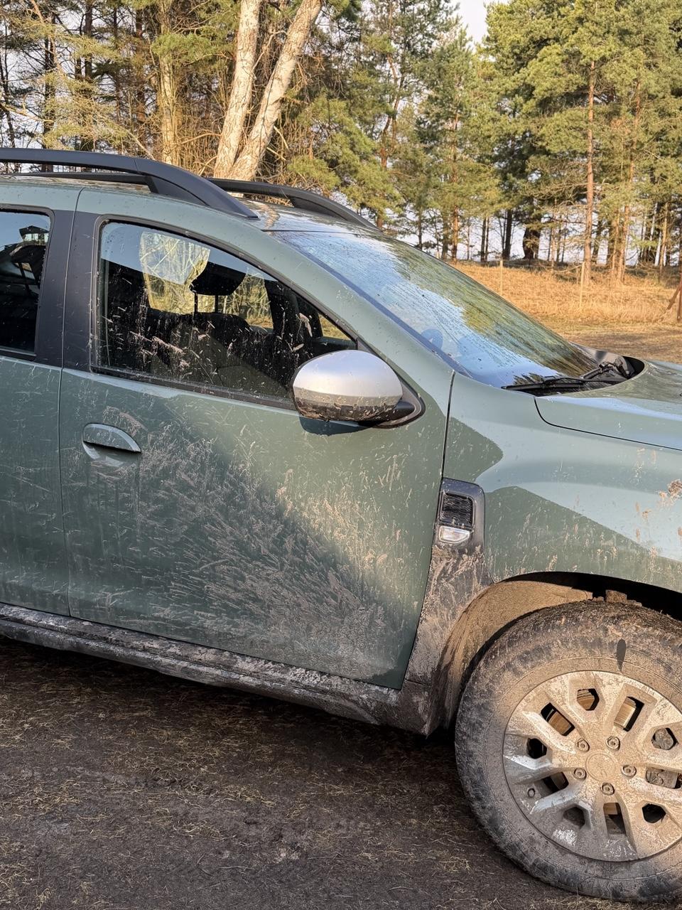Very dirty car, green-gray colored, much of it covered by mud